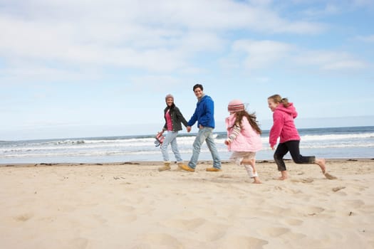 Family Walking Along Winter Beach
