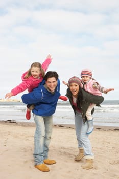 Family Walking Along Winter Beach