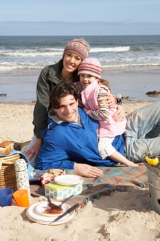 Family Having Barbeque On Winter Beach