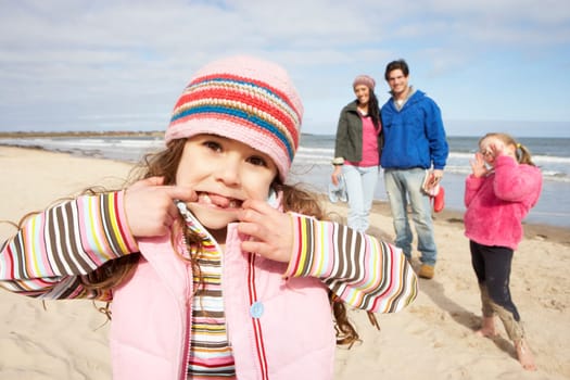 Family Walking Along Winter Beach