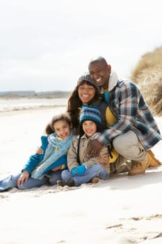 Family Sitting On Winter Beach