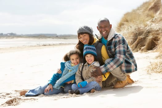 Family Sitting On Winter Beach
