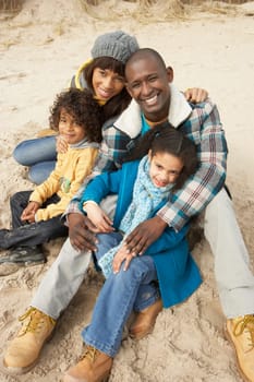Family Sitting On Winter Beach