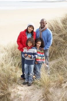 Family Walking In Dunes On Winter Beach