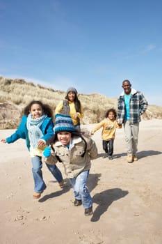 Family Running On Winter Beach