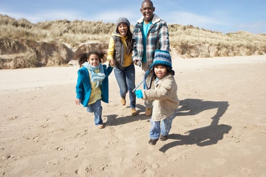 Family Running On Winter Beach