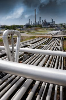 pipelines construction leading to refinery, dark storm clouds moving in over industry