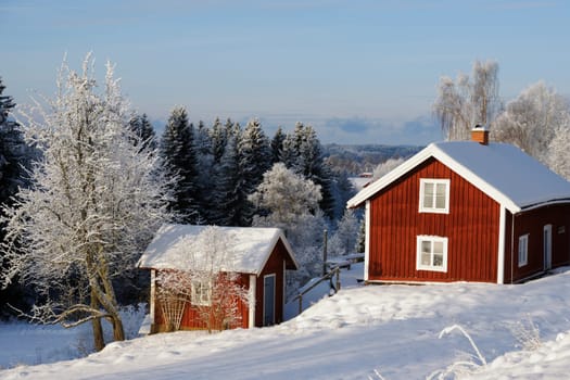 red cottages, surrounded by winter with snow and ice, typical swedish winter scenery