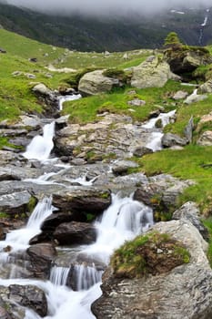 a small mountain river flowing among stones
