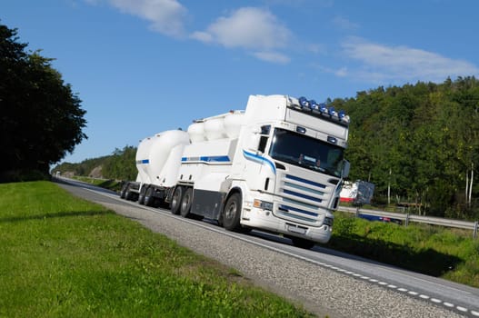 clean white fuel-truck, driving on scenic highway, ground level perspective. no trademarks.