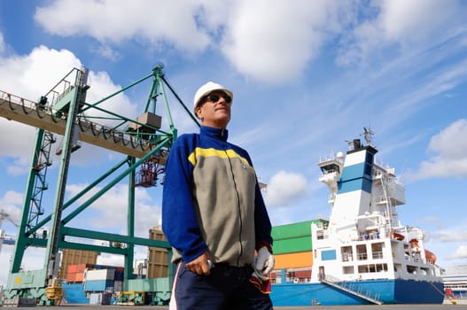 busy commercial container-port, shipping, with worker in foreground