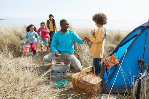 Young Family Relaxing On Beach Camping Holiday