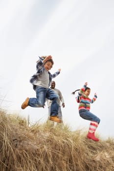 Father And Children Having Fun In Sand Dunes
