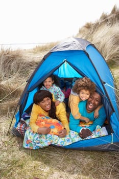 Young Family Relaxing Inside Tent On Camping Holiday
