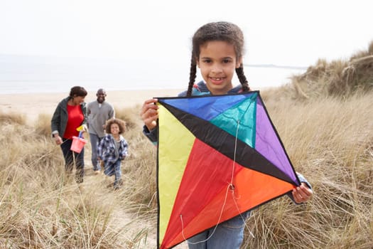 Family Having Fun With Kite In Sand Dunes