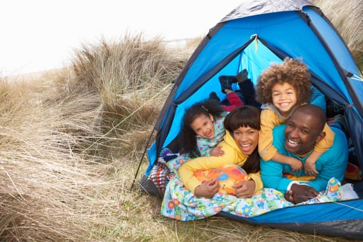 Young Family Relaxing Inside Tent On Camping Holiday