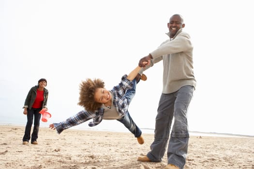 Young Family Relaxing On Beach Camping Holiday