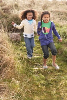Young Girls Playing In Field Together