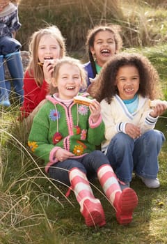 Group Of Girls Eating Cream Cakes In Field Together