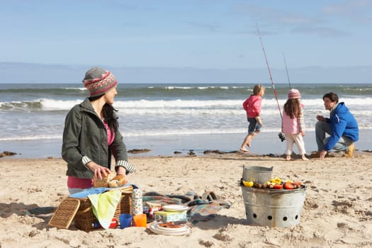 Family Having Barbeque On Winter Beach