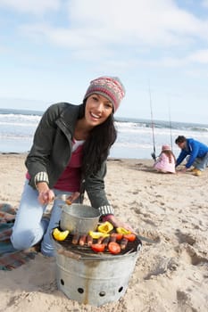 Family Having Barbeque On Winter Beach