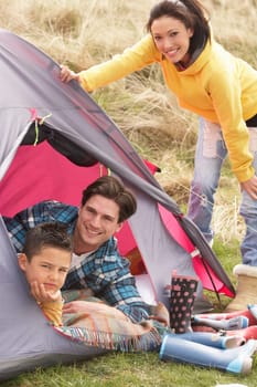 Young Family Relaxing Inside Tent On Camping Holiday