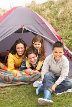 Young Family Relaxing Inside Tent On Camping Holiday
