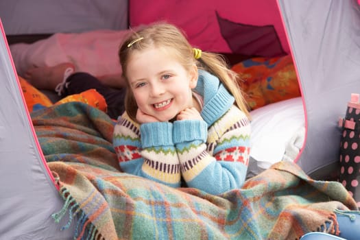 Young Girl Relaxing Inside Tent On Camping Holiday