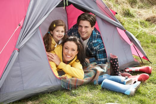 Young Family Relaxing Inside Tent On Camping Holiday