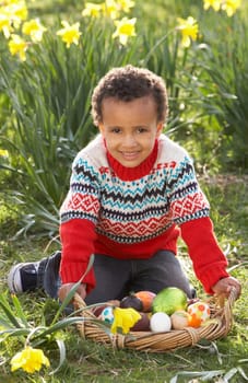 Boy On Easter Egg Hunt In Daffodil Field