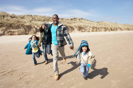 Family Running On Winter Beach