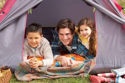 Young Family Relaxing Inside Tent On Camping Holiday