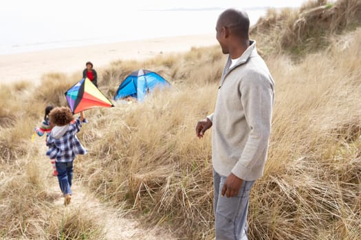 Family Having Fun With Kite In Sand Dunes