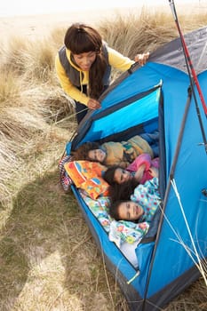 Young Family Relaxing Inside Tent On Camping Holiday
