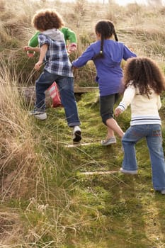 Group Of Children Playing In Field Together
