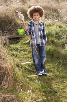 Young Boy Carrying Fishing Net At Seaside