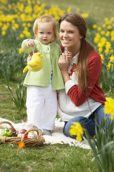 Mother And Daughter In Daffodil Field With Decorated Easter Eggs