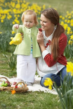 Mother And Daughter In Daffodil Field With Decorated Easter Eggs