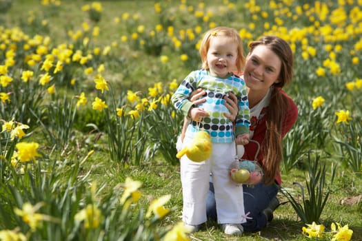 Mother And Daughter In Daffodil Field With Decorated Easter Eggs