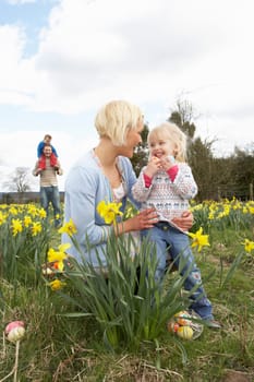 Family On Easter Egg Hunt In Daffodil Field
