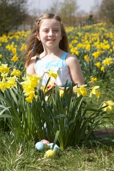 Girl On Easter Egg Hunt In Daffodil Field