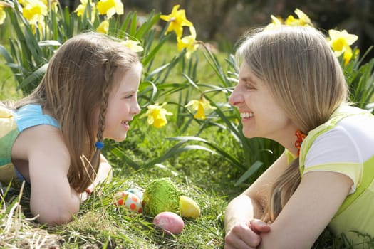 Mother And Daughter On Easter Egg Hunt In Daffodil Field