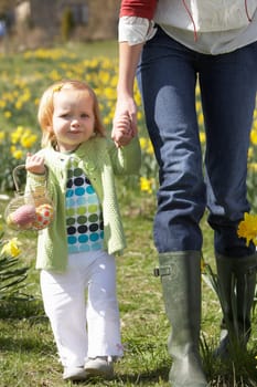 Mother And Daughter In Daffodil Field With Decorated Easter Eggs