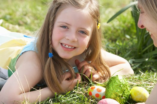 Mother And Daughter On Easter Egg Hunt In Daffodil Field