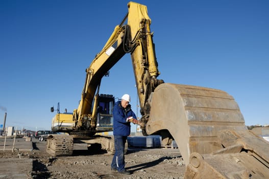 giant bulldozer, digger, mechanic fixing hydraulics system