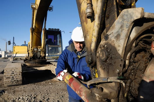 giant bulldozer being serviced by mechanic, close-ups.