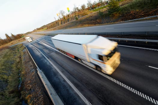 truck, driving at full speed, blurred motion, elevated view from bridge.