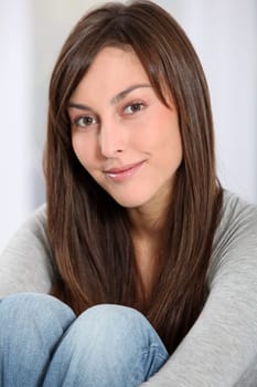 Beautiful woman sitting on sofa at home