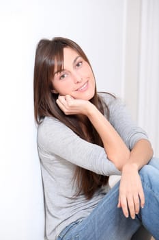 Beautiful young woman sitting on the floor