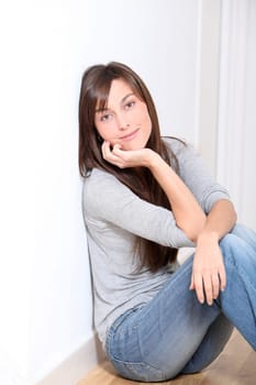 Beautiful young woman sitting on the floor